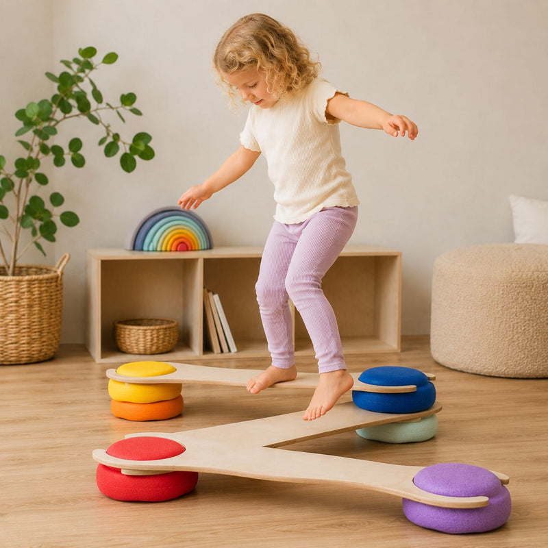 Kind balanciert auf Holz Balance Board mit bunten Steinen im Kinderzimmer und fördert spielerisch Gleichgewicht und Motorik