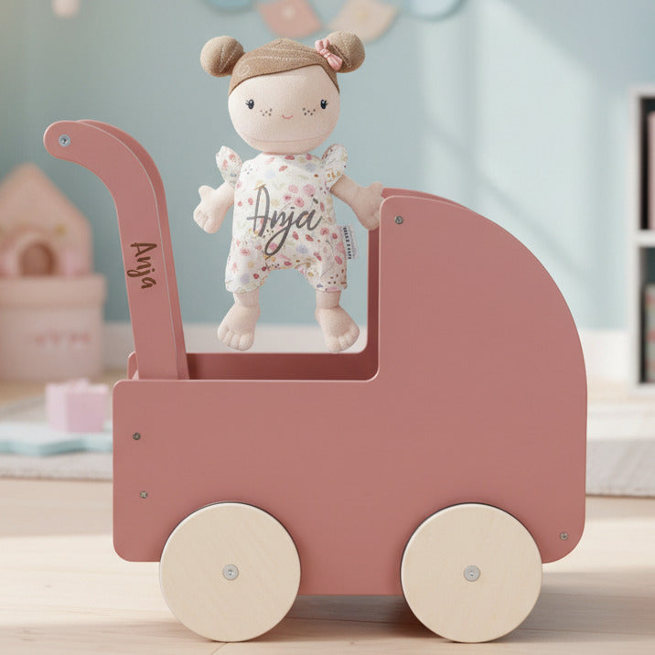 Personalisierter Holz-Puppenwagen mit Babypuppe und Name im Kinderzimmer. Hochwertiges Geschenk für Mädchen zum Geburtstag, zu Weihnachten oder zur Taufe. Individuell bei Schmatzepuffer personalisiert und ideal für Rollenspiele, Kreativität, Motorikförderung und langanhaltende Erinnerungen.