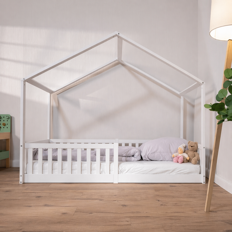 Weißes Montessori Hausbett im Kinderzimmer mit Rausfallschutz, Matratze und Kissen – gemütliches Bodenbett im skandinavischen Stil für Kinder